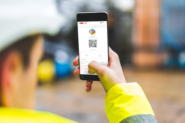 Safety manager spot checking construction subcontractor with QR code